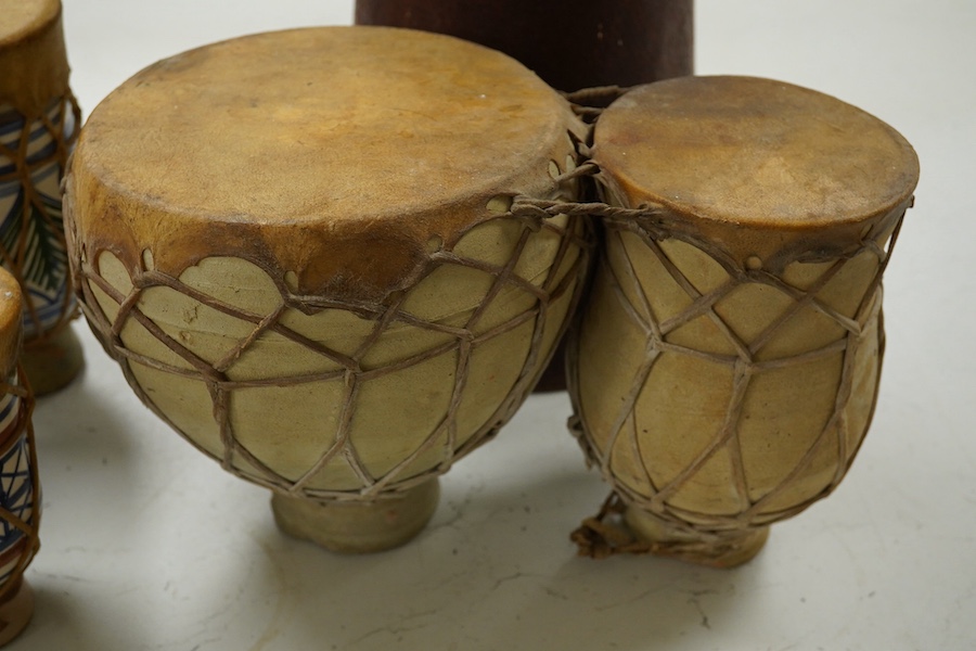 Five African drums; a Djembe, 60cm high, together with four small North African pottery double drums. Condition - fair to good.